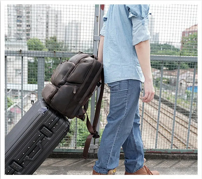 Dark brown genuine leather men's backpack showing 17-inch computer compartment and multiple interior pockets