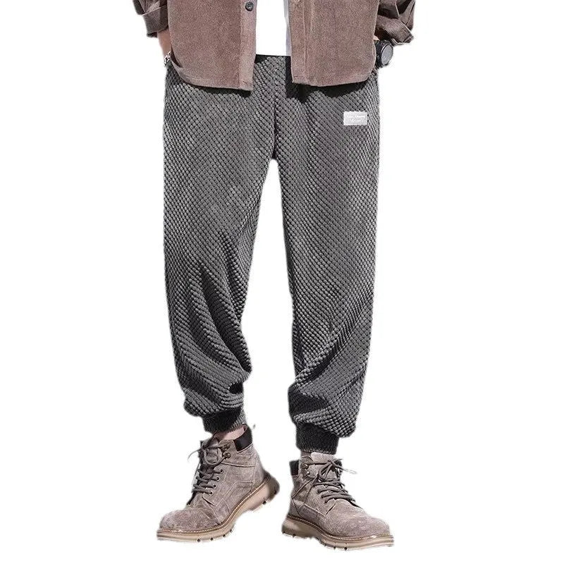 Men's grey ankle-tied straight-leg sweatpants laid flat, showing non-ironing casual design.