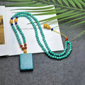 Turquoise mesh flower lucky pendant necklace with ball bead chain on a white background