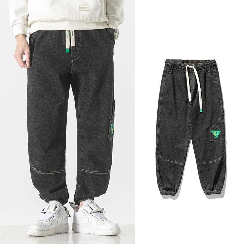 Men's loose-fit tapered cotton trousers in black, blue, or grey on a mid-waist.