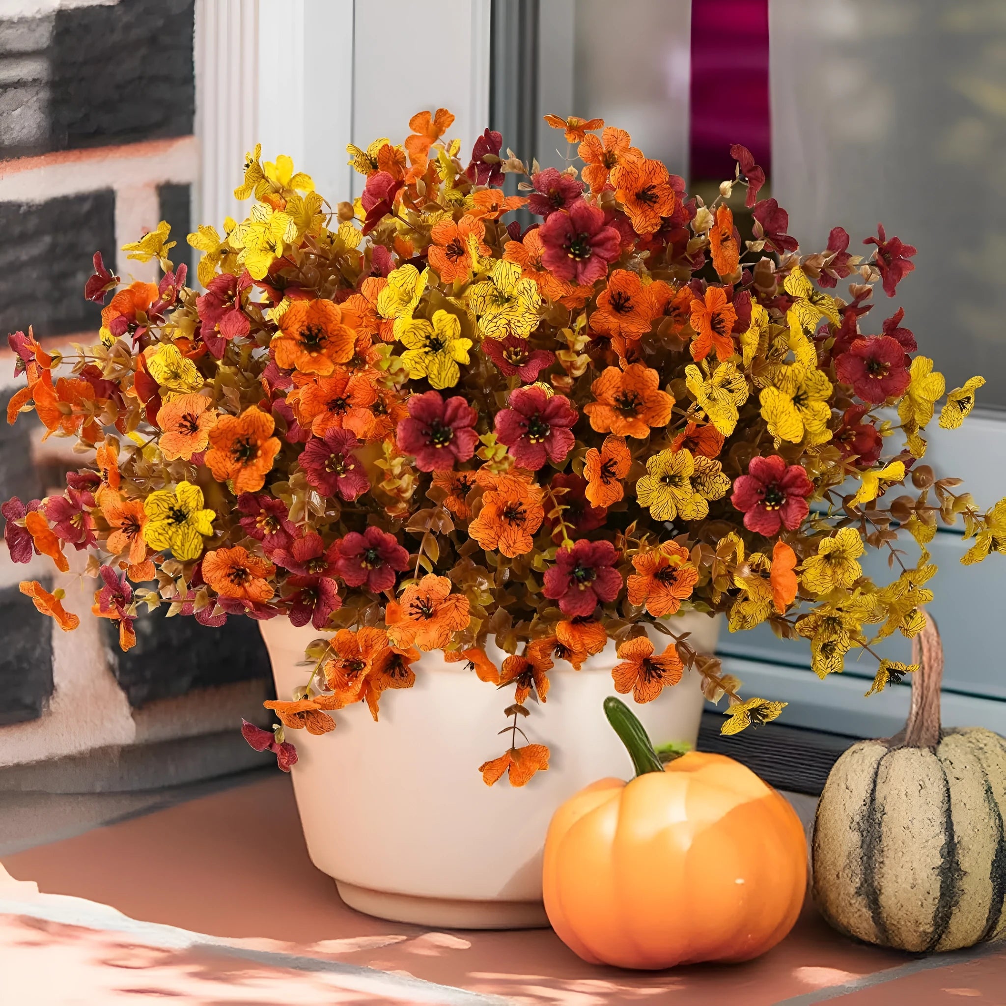 Artificial flower bouquet in autumn orange, red, and yellow colours for home or wedding decoration.
