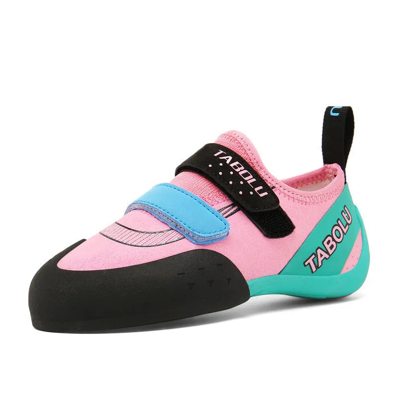 A pair of beginner rock climbing shoes with Velcro straps, shown in a black and red colour scheme.