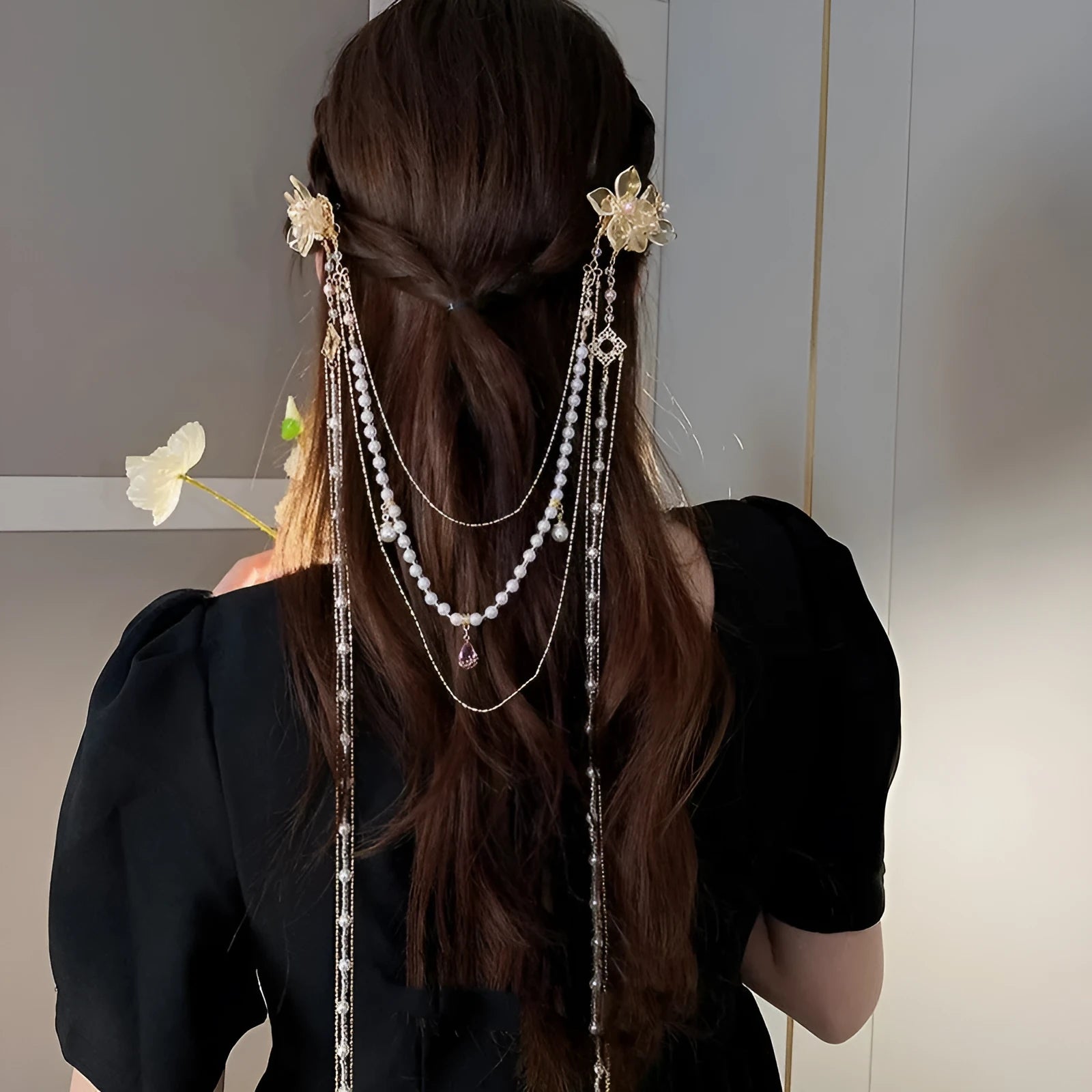 Gold coloured women's hairpin with a pearl, diamond flower and long decorative tassels.