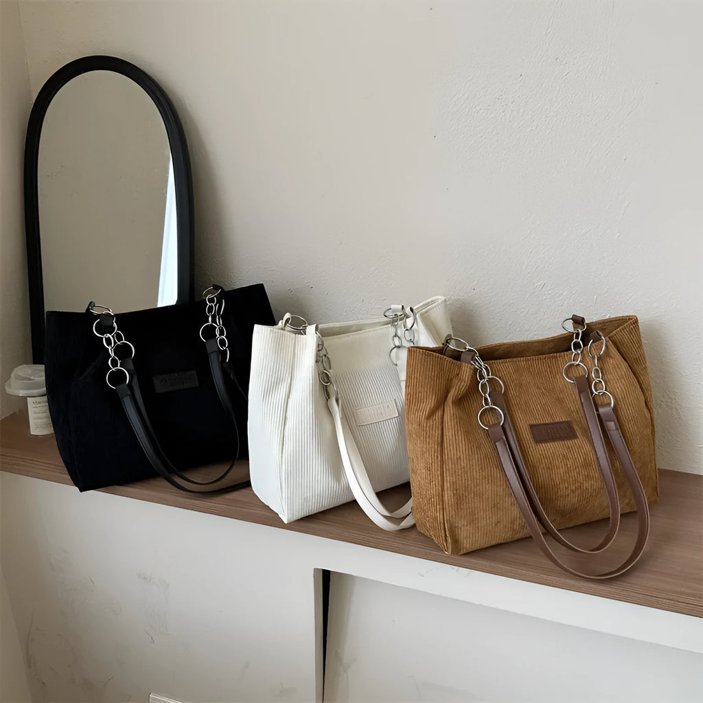 Corduroy one-shoulder tote handbag in a horizontal square shape with a three-dimensional outer pocket.