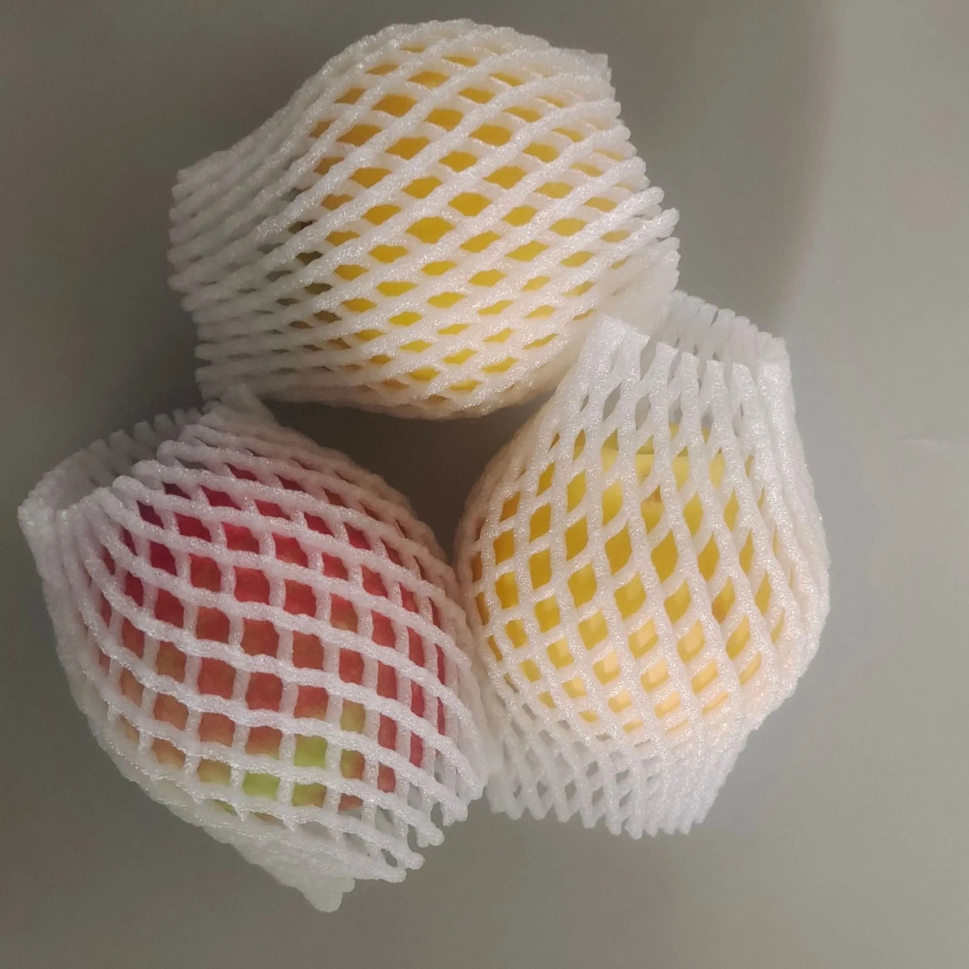 White foam net covers for fruit protection in multiple sizes on various fruits