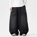 Man wearing black plus-size baggy denim jeans with a straight leg and low waist.