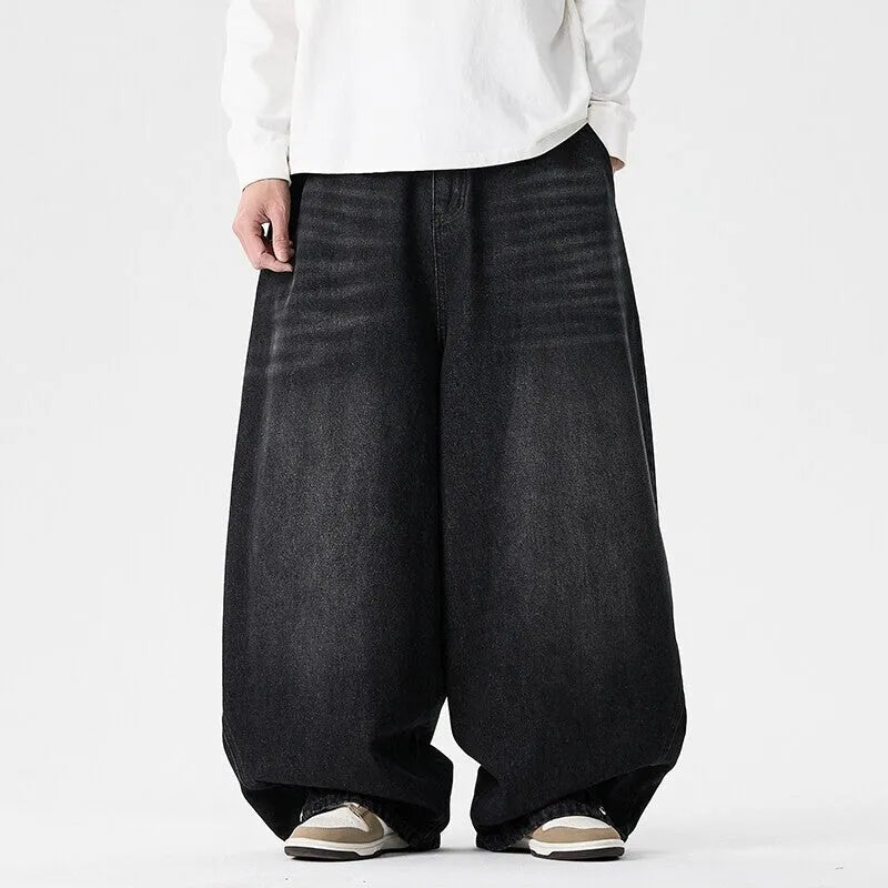 Man wearing black plus-size baggy denim jeans with a straight leg and low waist.