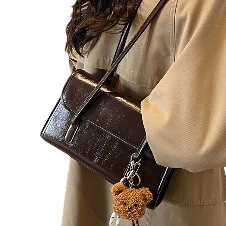 Women's brown PU Maillard shoulder bag with pendant detail, showing horizontal square shape and double straps.