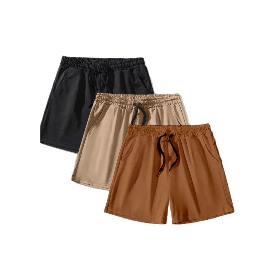 Three pairs of men's solid colour elastic shorts in black, khaki and light brown on a white background