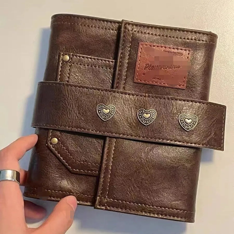 Brown retro leather-style A7 notebook with a buckle closure, shown open to reveal loose-leaf binder binding.