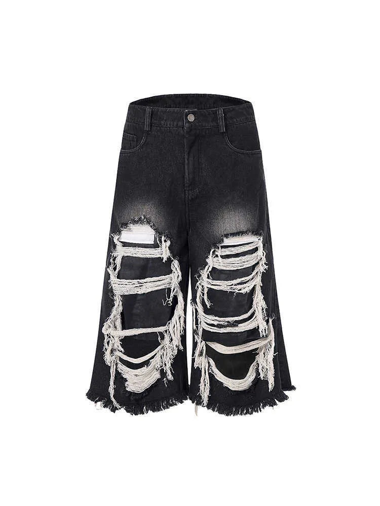 Black women's wide leg cropped jeans with ripped patch detail and a mid-high waist on a hanger.
