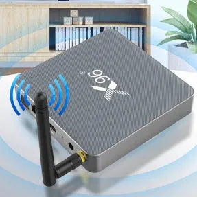 Android smart TV set-top box with voice control remote on a table next to a television.