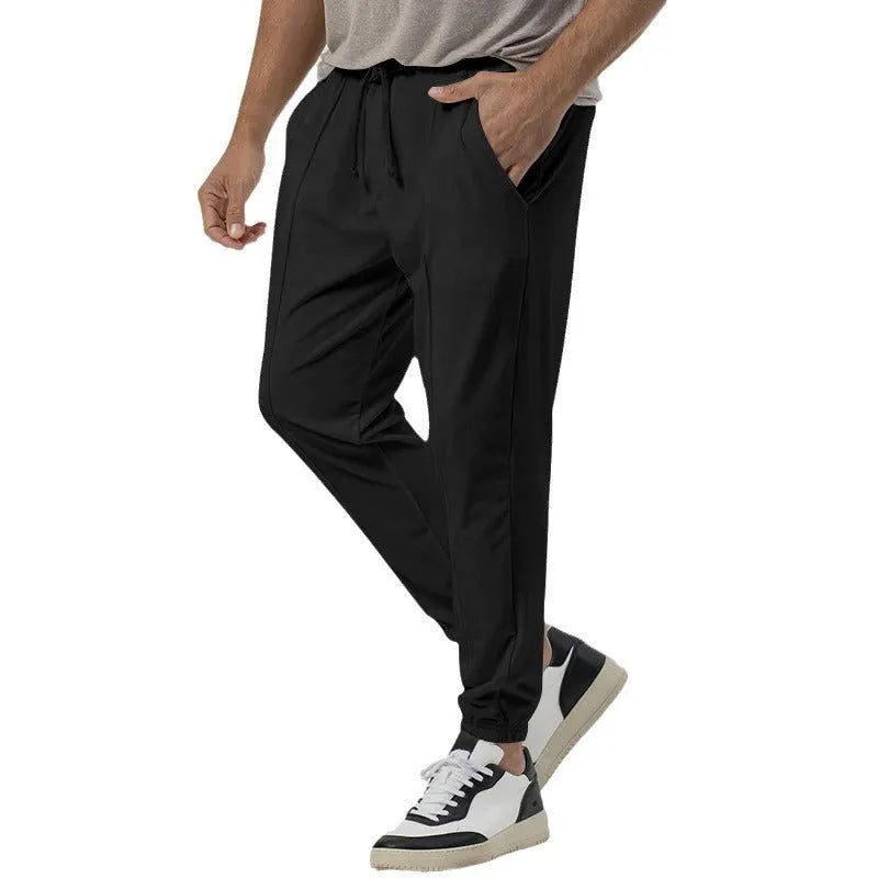 Men's grey casual track sweatpants with straight-leg design and mid waist, made from polyester blend elastic fabric