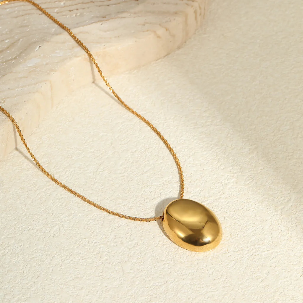 Gold geometric pendant necklace with adjustable chain on jewellery display