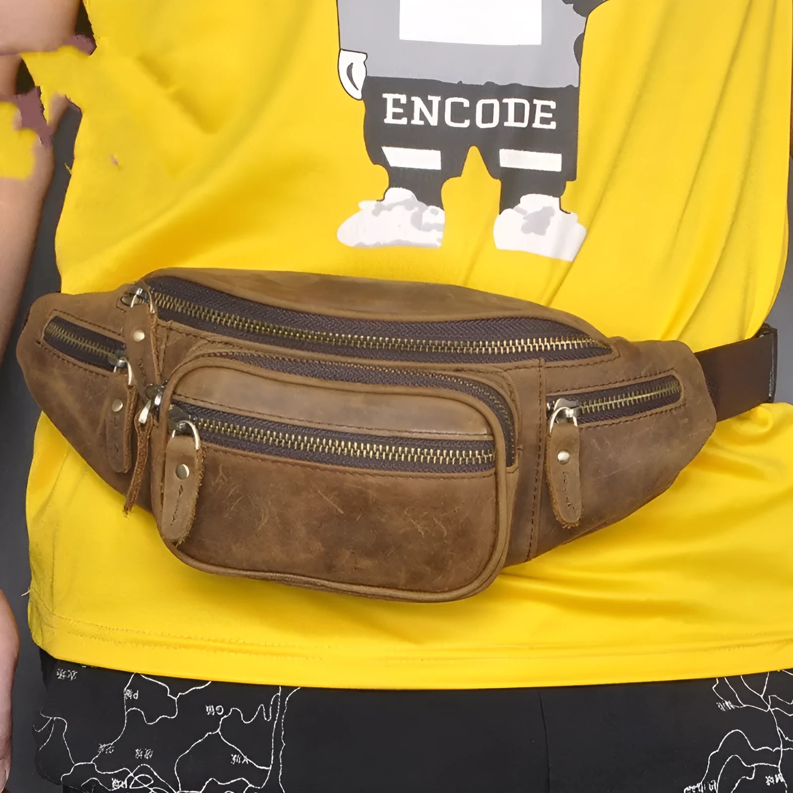 Brown cowhide leather messenger bag with a single shoulder strap, shown closed.