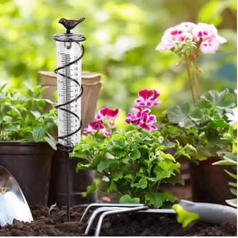 Cast iron hummingbird garden rain gauge with glass measurement tube showing 1-20 scale