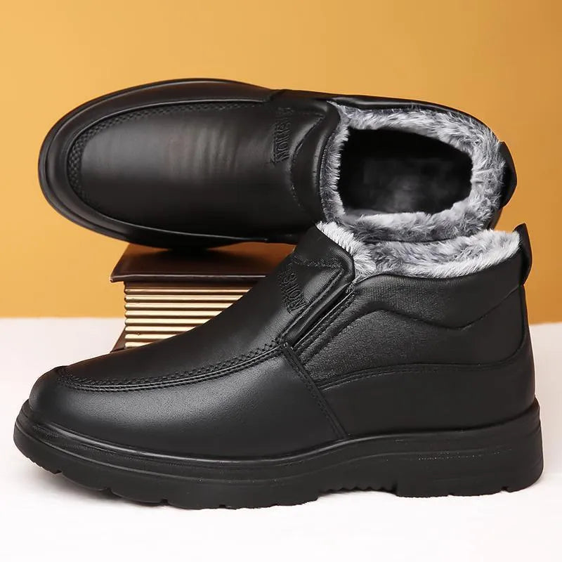 Men's black fleece-lined winter slip-on shoes with a non-slip rubber sole on a wooden floor.