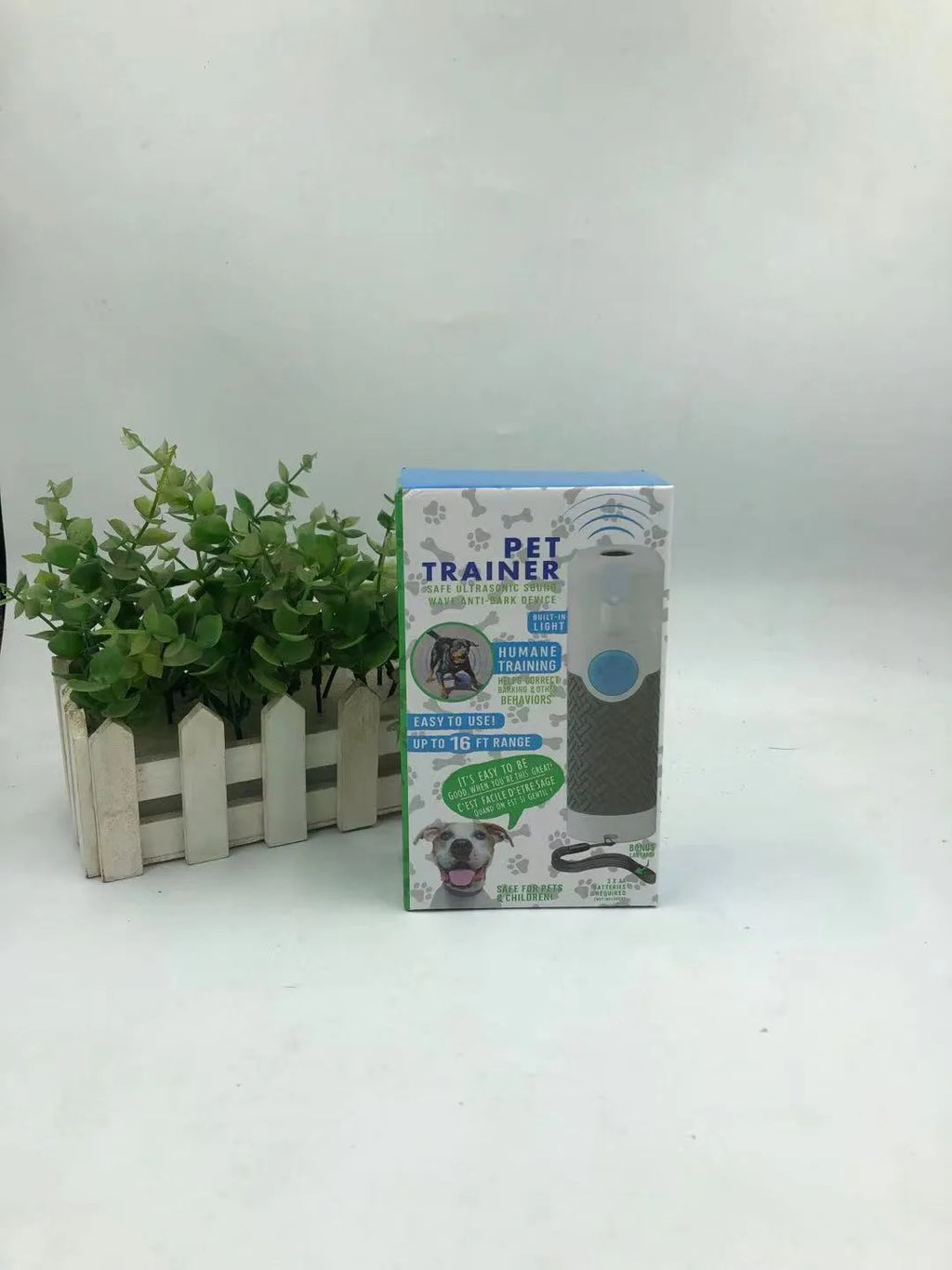 White handheld ultrasonic dog bark control device on plain background