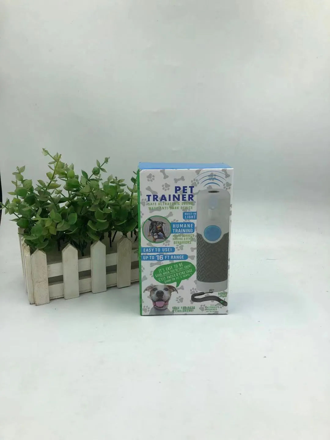 White handheld ultrasonic dog bark control device on plain background