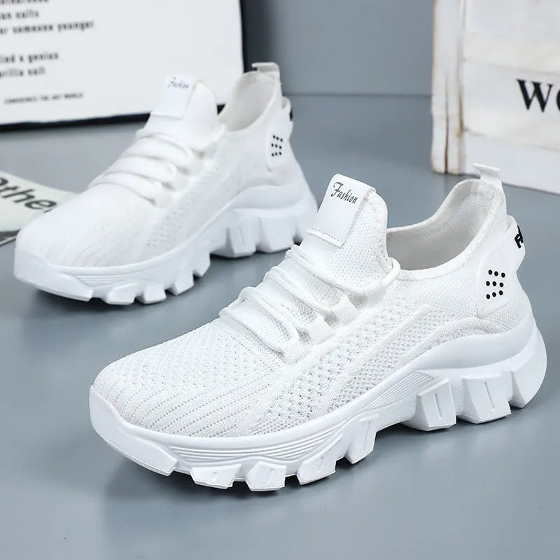 Women's white Flyknit running sneakers with a thick PVC sole and lace-up front.