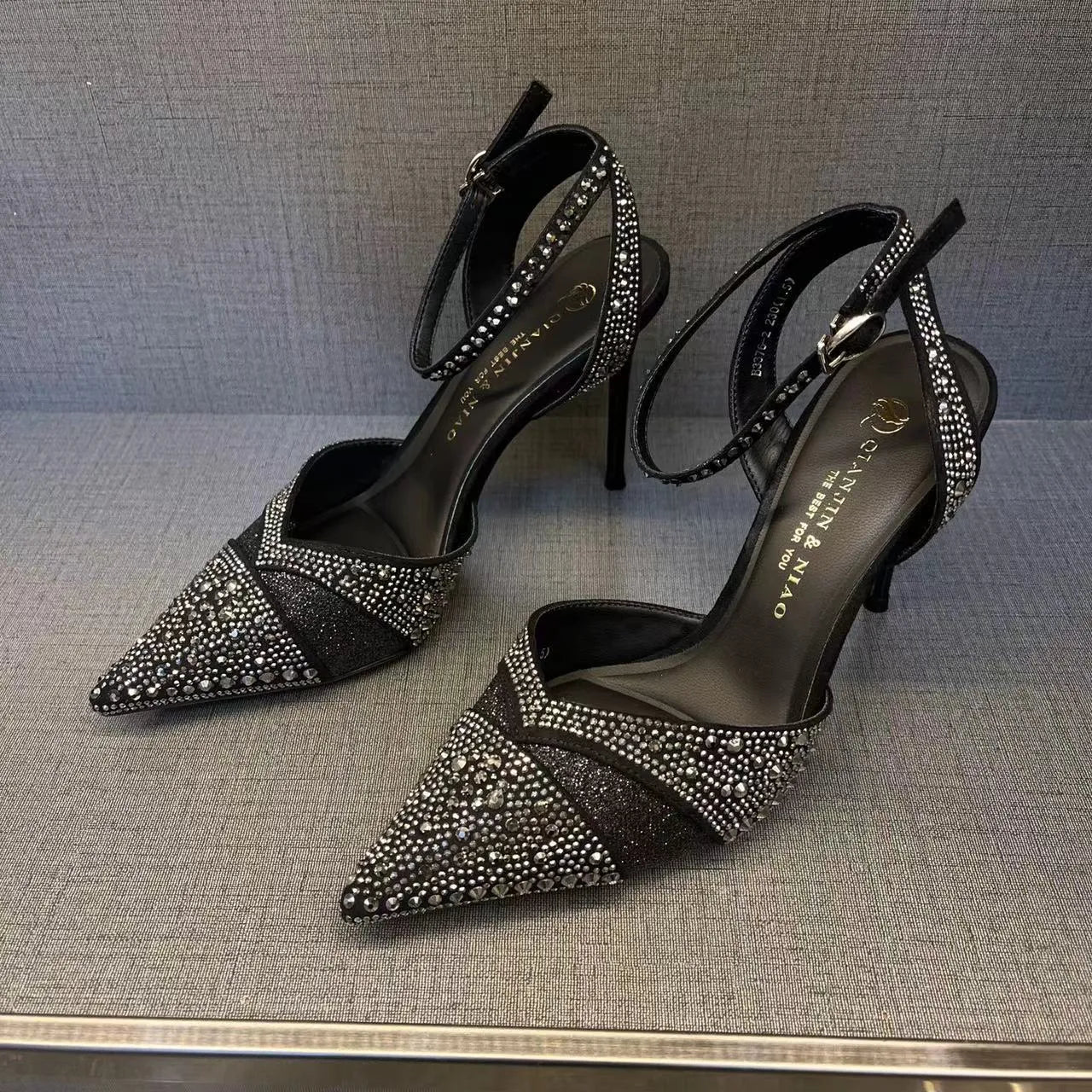 Women's black stiletto heels with pointed toe, hollowed design and red sole