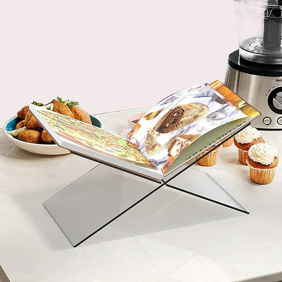 Clear acrylic X-shaped desktop book display rack holding an open book and magazine