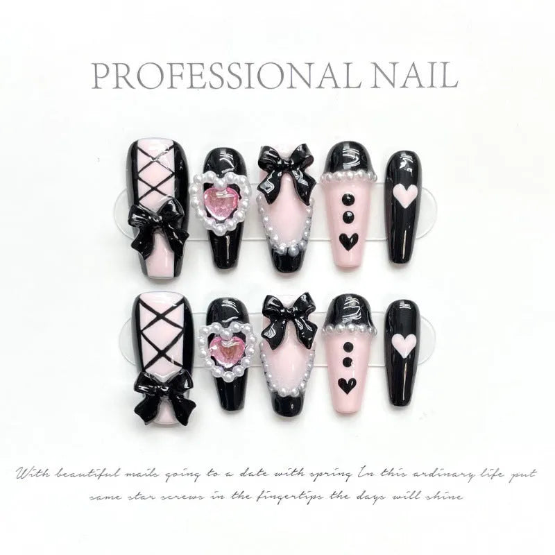 Hand-painted black and pink peach heart design on a detachable plastic manicure set with Bow and XINGX patterns.