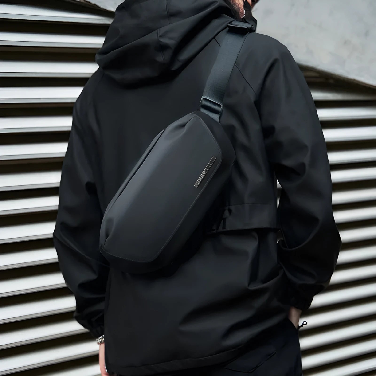 Black Oxford cloth messenger bag for men with visible stitching, shown for one-shoulder carry.