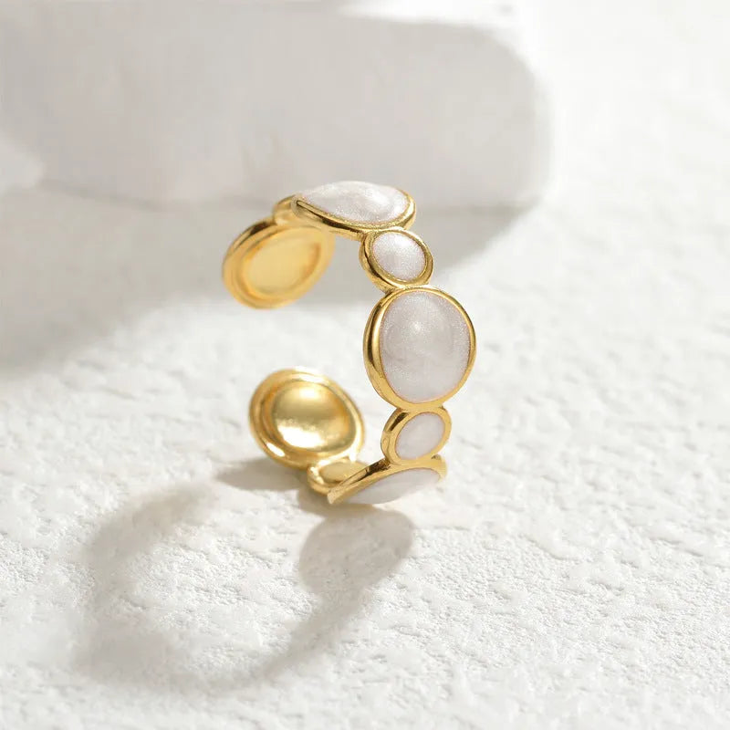 Adjustable geometric stainless steel ring for women on a plain background.