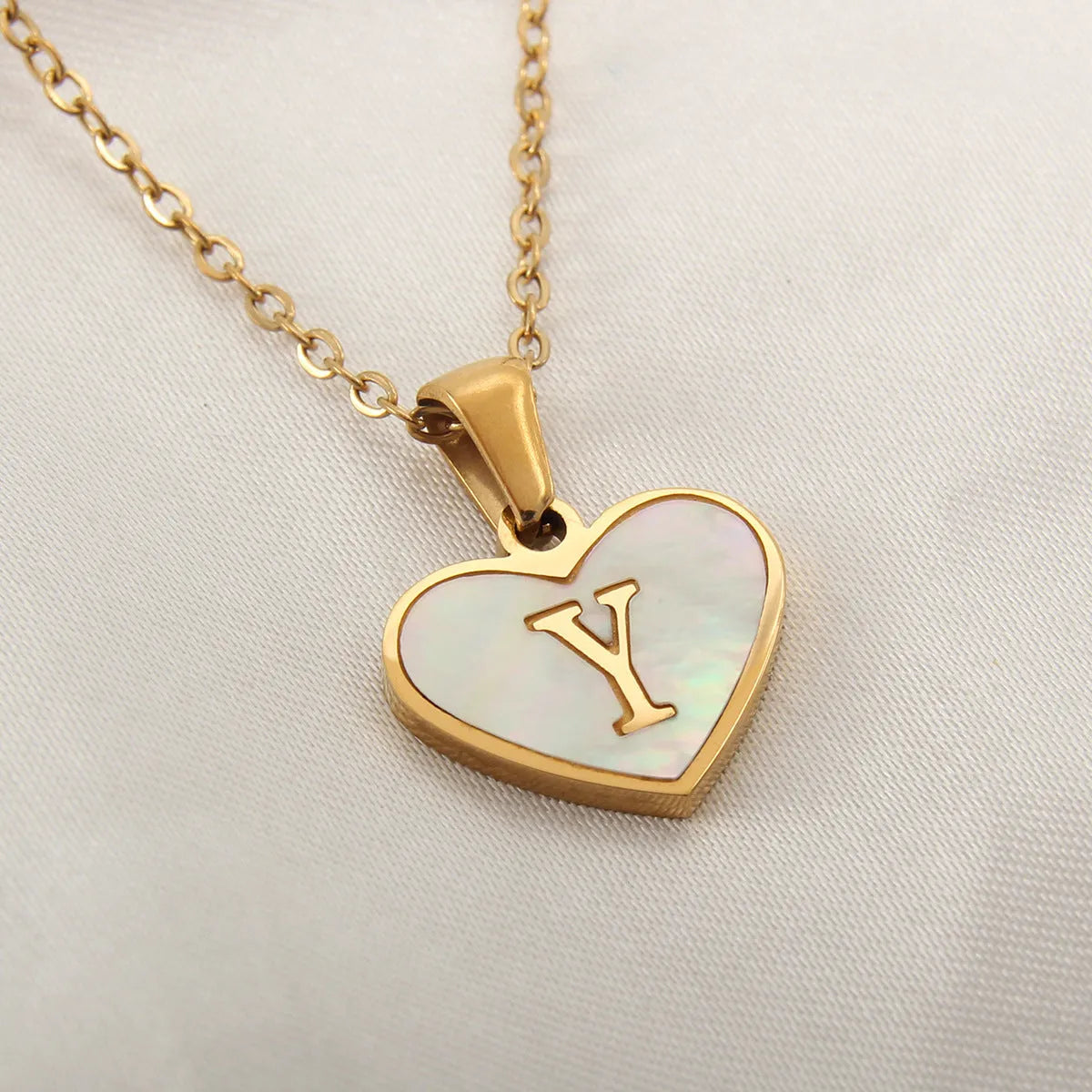 Gold plated initial necklace with white shell heart pendant and adjustable chain