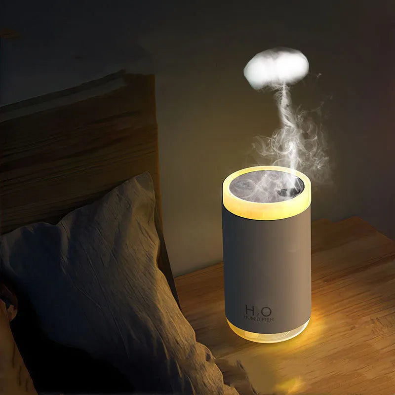 White jellyfish-shaped USB humidifier with warm night light on a wooden table.