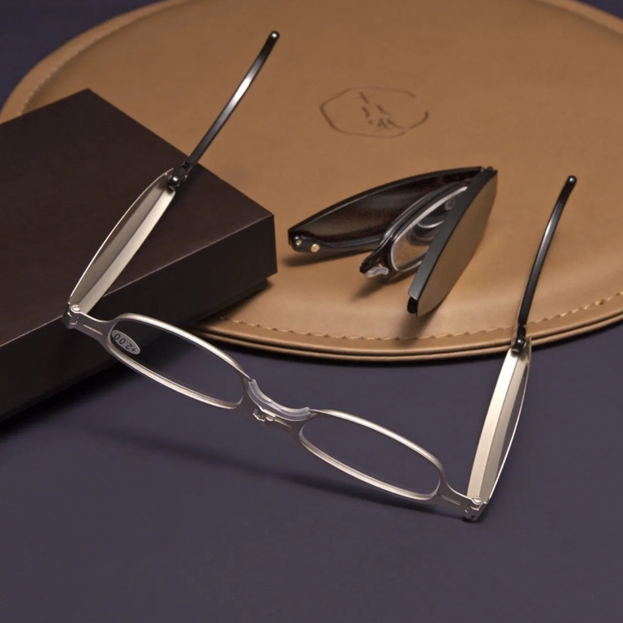 Folding presbyopic glasses in black retro frame showing ring detail and folded position