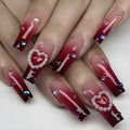 Wine red gradient fake nail tips with a pearl heart and plaid design in a long ballet shape.