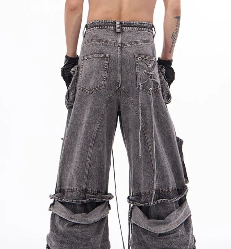 Grey distressed denim overalls with rope stitching on a hanger.