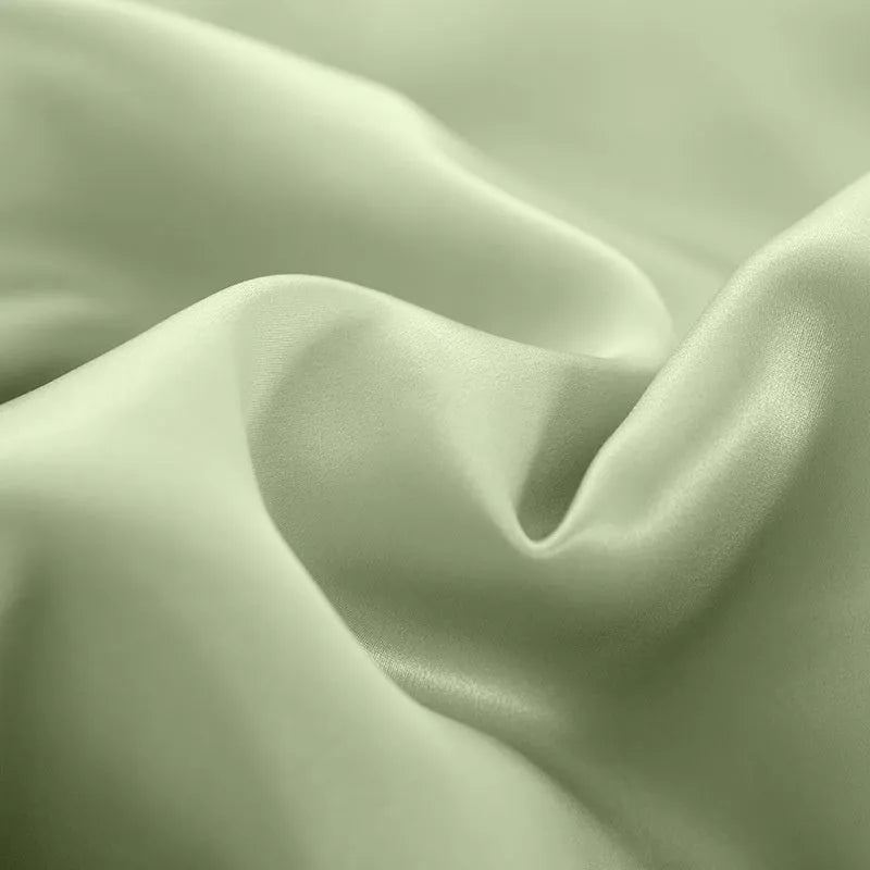 Solid colour silk duvet cover shown in Lotus Pink, laid flat on a bed.