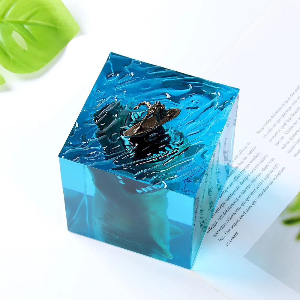 Clear epoxy resin ornament with shark surfing scene inside, on a plastic lamp holder base.