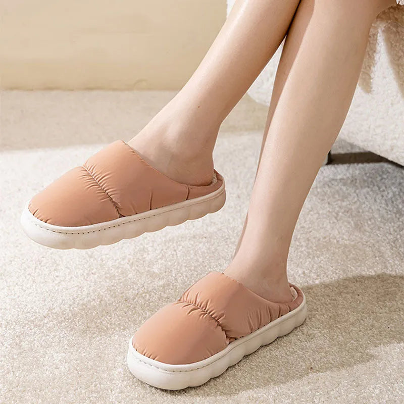 A pair of thick-soled plush slippers with artificial leather uppers and non-slip rubber soles in a choice of five colours.