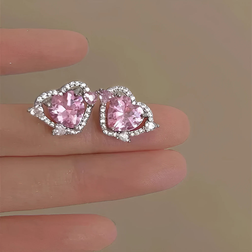 A pair of women's heart-shaped stud earrings with a white K electroplated finish on a copper base.