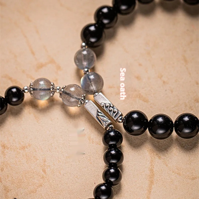 Obsidian Buddha beads couple bracelet set showing 8mm women's and 10mm men's sizing differences