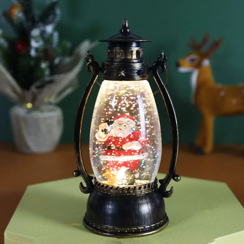 Plastic crystal ball LED oil lamp Christmas ornament with internal snowman figurine on a desktop.