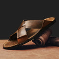 Men's black genuine leather slip-on sandals with a rubber sole on a plain background.