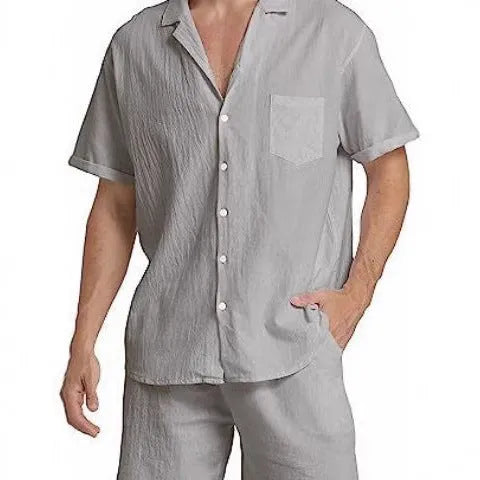 Man wearing a light grey short-sleeved Flax top and matching shorts from a summer sports suit set.