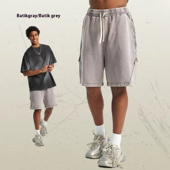 Man wearing loose-fit batik washed cotton terry shorts in a retro style with patch craft details.