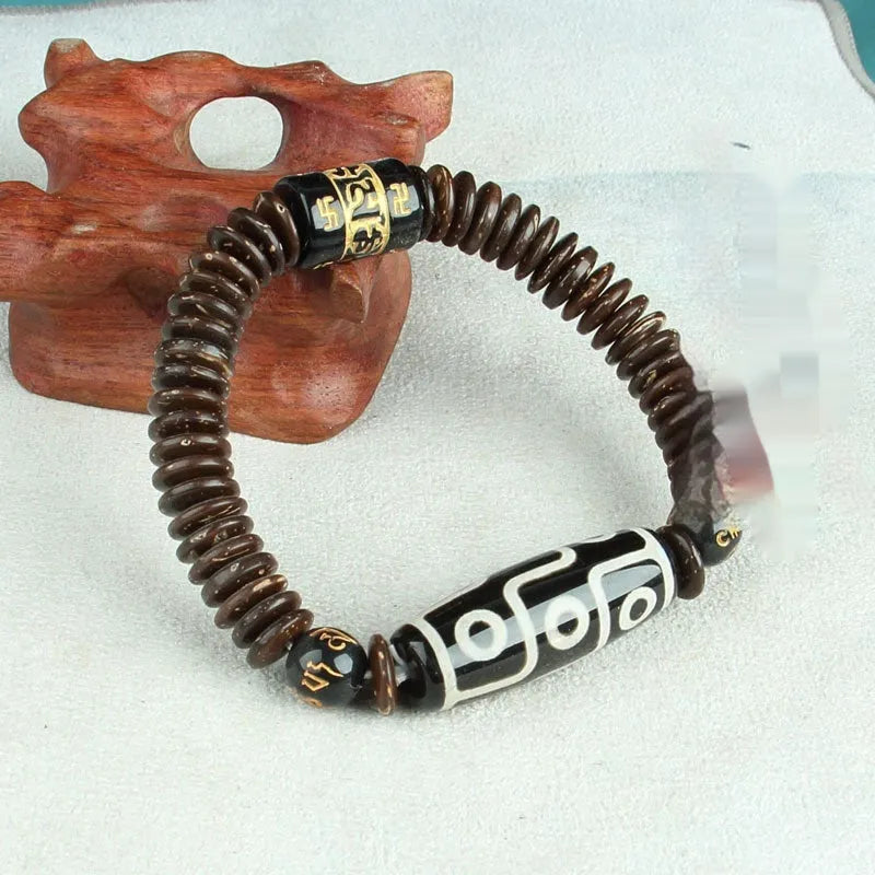 Distressed agate Tibetan bead bracelet with three-eye motifs and polished finish.