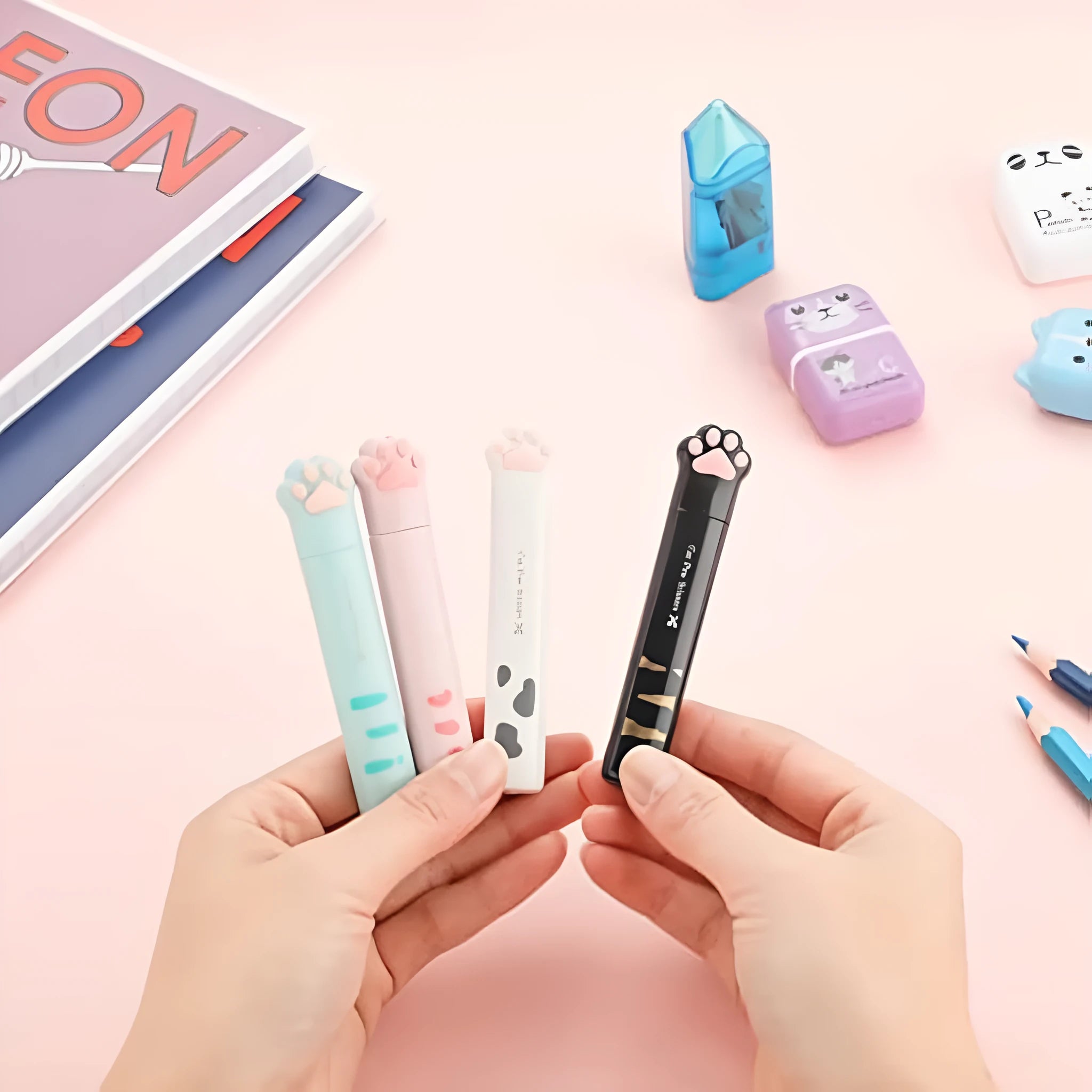 Closed folding mini scissors with cat paw design on handles in blue, pink, black, and white colour options.