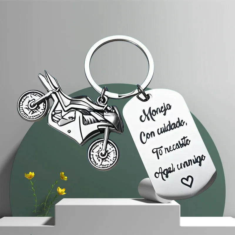 Stainless steel motorcycle keychain with inspirational text and a flannel storage bag.