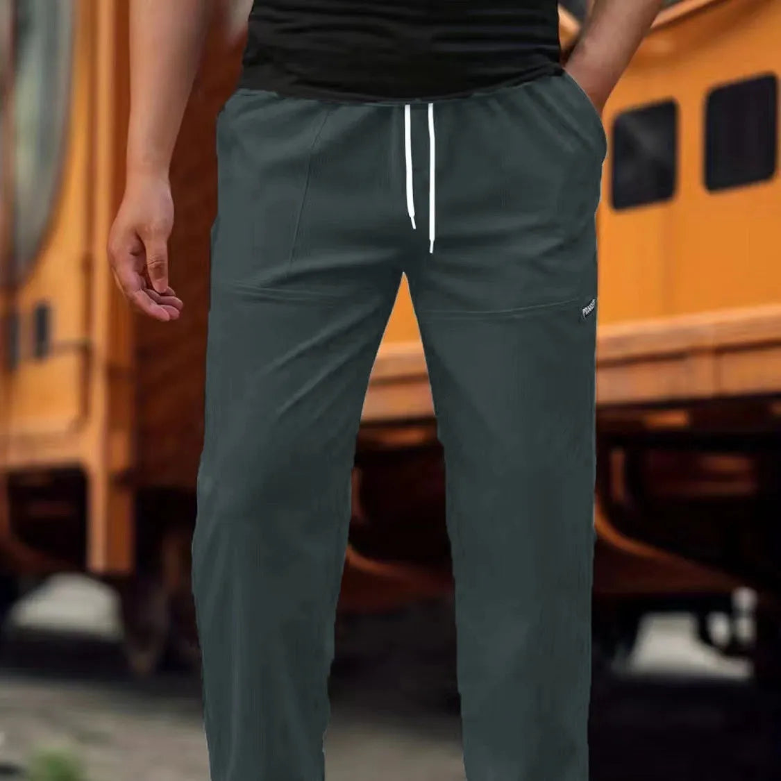 Men's polyester trousers in light grey, shown flat, with a size label indicating S-XXXL range.