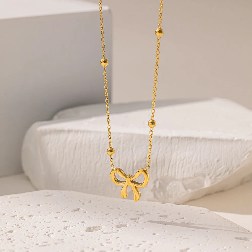 Gold-coloured women's bow necklace with cross chain design on adjustable 41-50cm perimeter