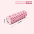 A black EVA foam roller on a floor, a fitness tool for muscle recovery and yoga.