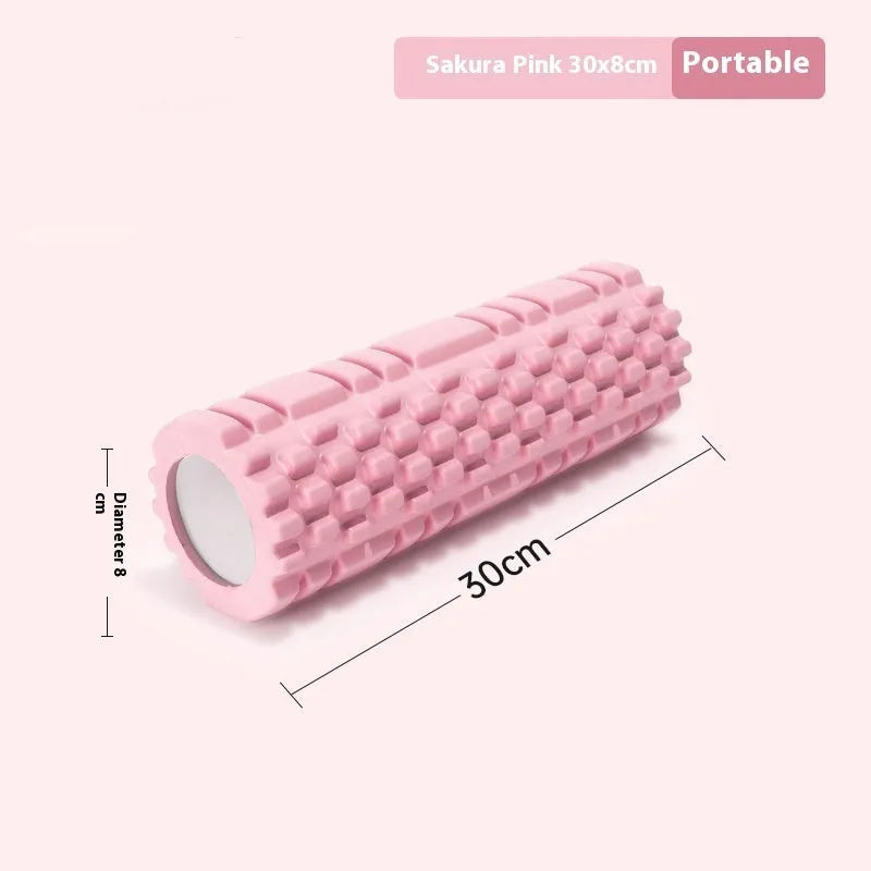 A black EVA foam roller on a floor, a fitness tool for muscle recovery and yoga.